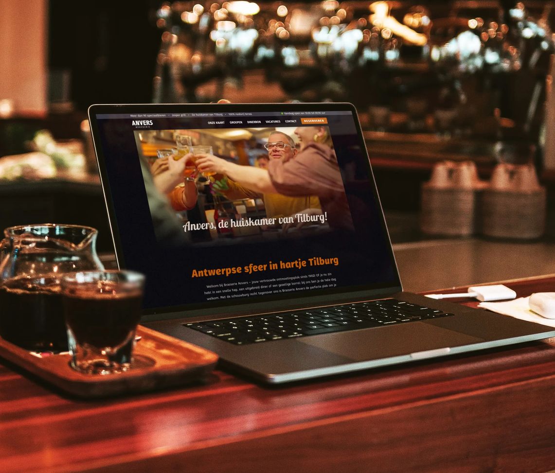 Een laptop op de bar waar de homepage van Anvers wordt weergegeven.